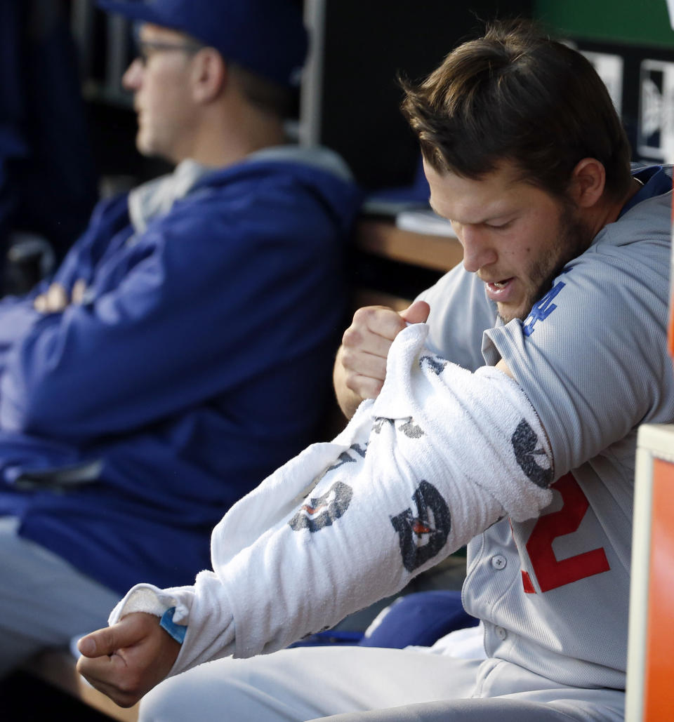 Los Angeles Dodgers pitcher Clayton Kershaw (22) wraps his arm in a towel during the third inning of a baseball game against the Washington Nationals at Nationals Park, Tuesday, May 6, 2014, in Washington. (AP Photo/Alex Brandon)