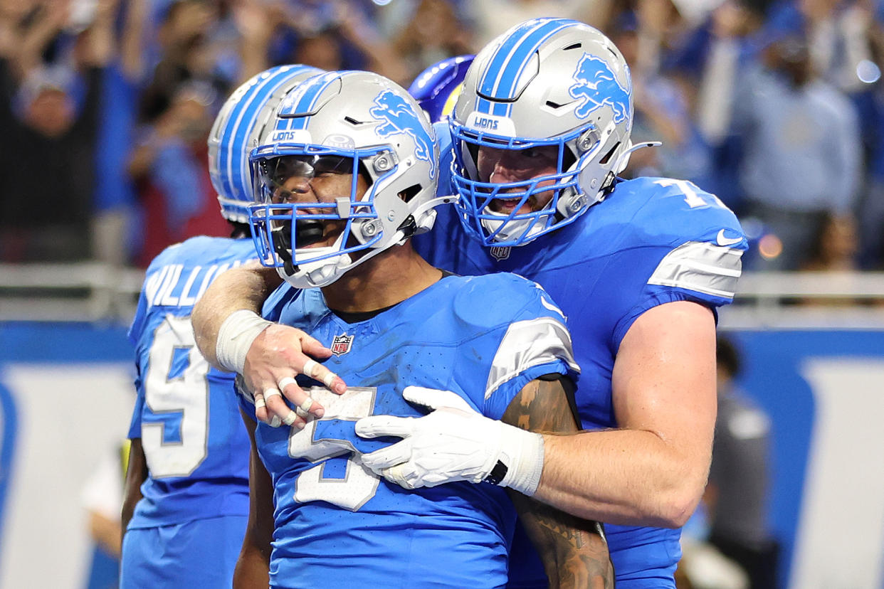 DETROIT, MICHIGAN - SEPTEMBER 08: David Montgomery #5 of the Detroit Lions celebrates with Frank Ragnow #77 after scoring a touchdown in overtime to beat the Los Angeles Rams 26-20 at Ford Field on September 08, 2024 in Detroit, Michigan. (Photo by Gregory Shamus/Getty Images)