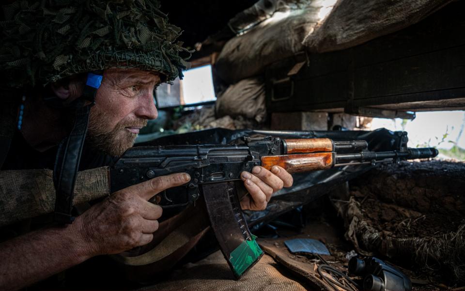 A Ukrainian soldier holds his position inside a trench