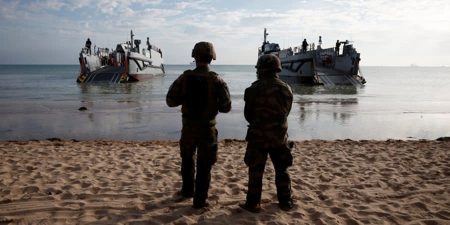 French soldiers at Normandy coast at Omaha beach American landing, with US ships behind them during a historical reconstruction of the event jointly with the USA, June 4, 2024