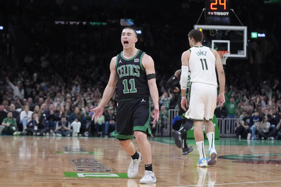 Boston Celtics guard Payton Pritchard celebrates after scoring, while Milwaukee Bucks center Brook Lopez heads to the other end of the court during the first half of an NBA basketball game Wednesday, March 20, 2024, in Boston. (AP Photo/Steven Senne)