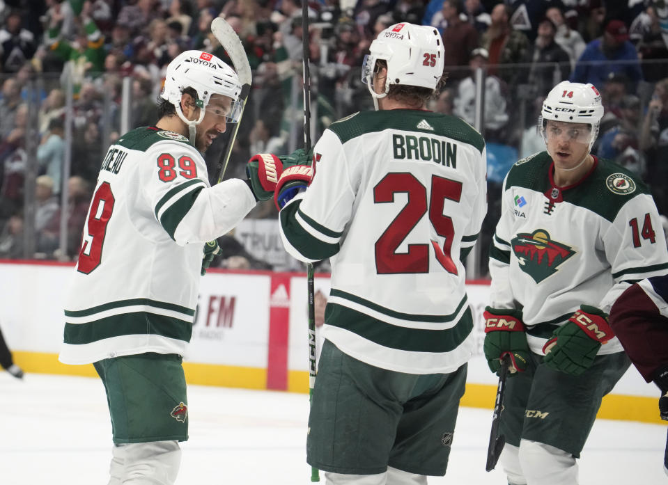 From left, Minnesota Wild center Frederick Gaudreau is congratulated after scoring an empty-net goal by defenseman Jonas Brodin and center Joel Eriksson Ek late in the third period of an NHL hockey game against the Colorado Avalanche Wednesday, March 29, 2023, in Denver. (AP Photo/David Zalubowski)