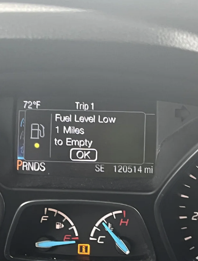 Car dashboard showing a 72°F temperature, Trip 1 details, fuel gauge warning "Fuel Level Low" with "1 Miles to Empty," PRNDS indicator, and 120514 miles odometer