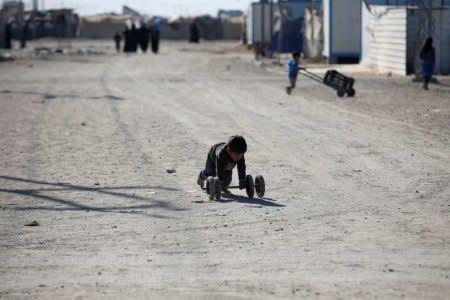 FILE PHOTO: A displaced Iraqi boy plays at the Amriyat al Fallujah camp in Anbar Province, Iraq January 3, 2018. REUTERS/Khalid al-Mousily