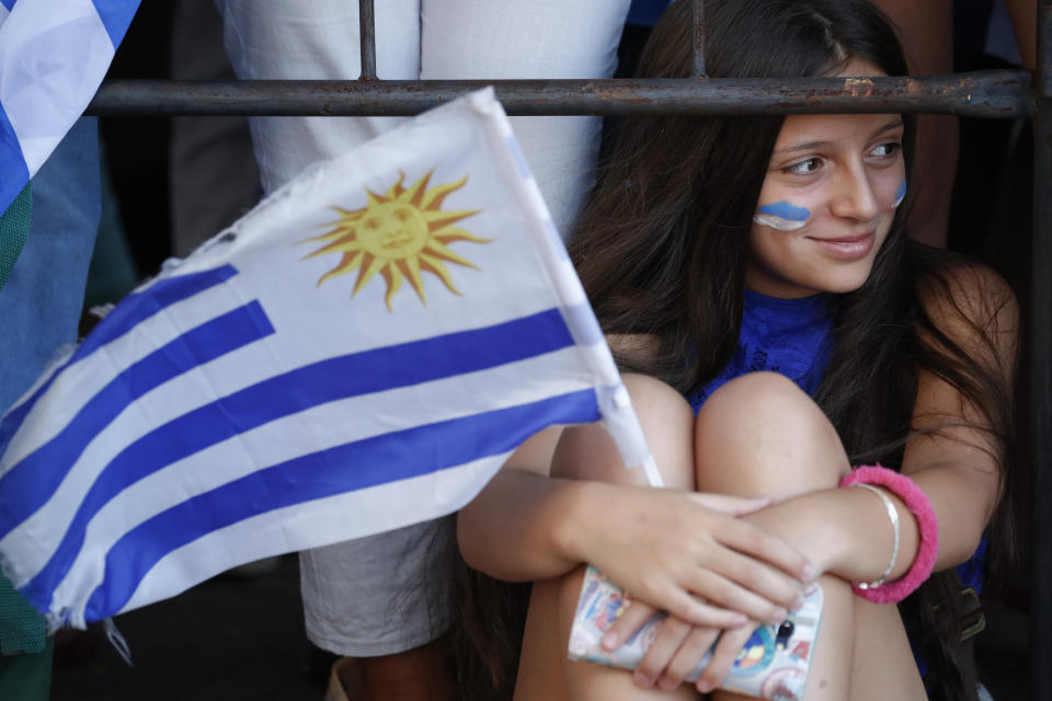 A supporter of Uruguay's new President Luis Lacalle Pou waits for his arrival to Congress in Montevideo, Uruguay, Sunday, March 1, 2020. Lacalle Pou is taking office in Uruguay, promising to crack down on crime and tighten government finances after a 15-year string of left-leaning governments. (AP Photo/Natacha Pisarenko)