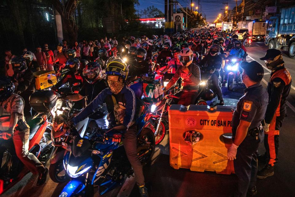 Motorists fall in line at a health checkpoint as authorities begin implementing lockdown measures on March 16, 2020 in San Pedro, Laguna province, on the outskirts of Metro Manila, Philippines.