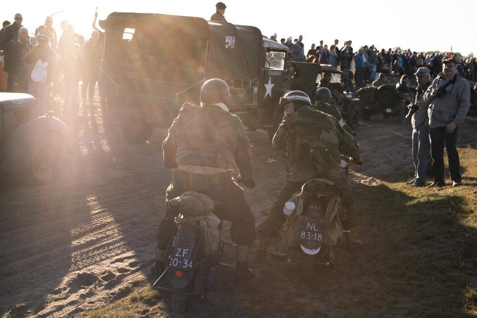 Spectators watch a parade of historic WWII military vehicles prior to a mass parachute drop at Ginkel Heath, eastern Netherlands, Saturday, Sept. 21, 2019, as part of commemorations marking the 75th anniversary of Operation Market Garden, an ultimately unsuccessful airborne and land offensive that Allied leaders hoped would bring a swift end to World War II by capturing key Dutch bridges and opening a path to Berlin. (AP Photo/Peter Dejong)