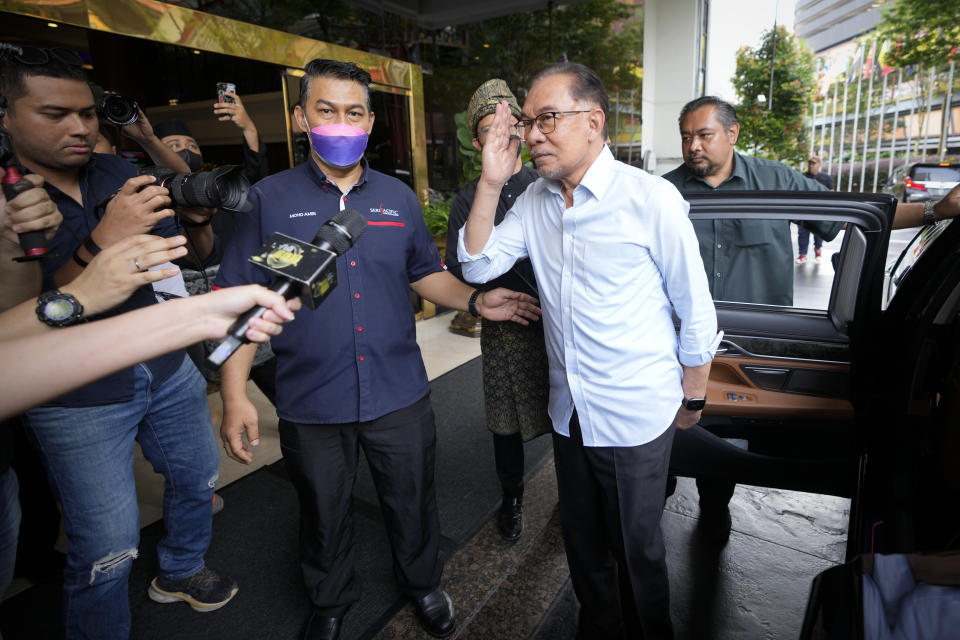 Malaysian opposition leader Anwar Ibrahim, center, arrives at a hotel to meet the leaders of United Malays National Organization in Kuala Lumpur, Malaysia, Monday, Nov. 21, 2022. Anwar's reformist alliance topped the race with 82 seats, but fell far short of a majority. Both camps have said they can gain a majority. But the decision is up to the king. (AP Photo/Vincent Thian)