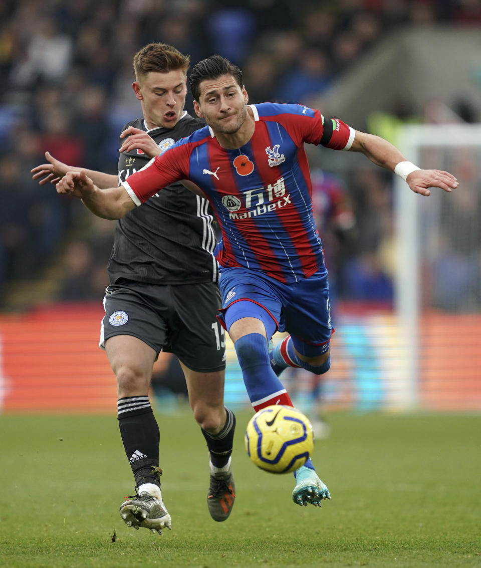 Leicester City's Harvey Barnes, left, and Crystal Palace's Joel Ward battle for the ball during the English Premier League soccer match at Selhurst Park, London, Sunday Nov. 3, 2019. (John Walton/PA via AP)