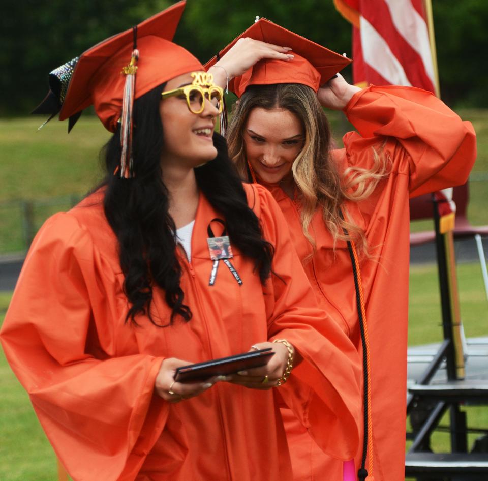 Plainfield High School graduates and twins Gabriella Fitch, left, and Isabella Fitch smile after getting their diplomas during their commencement exercises Friday. There were 114 graduates.