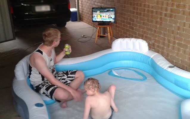 Stuart watches footy with his brother while relaxing in the pool. Source: Facebook