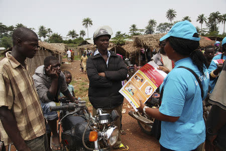 A UNICEF worker speaks with drivers of motorcycle taxis about the symptoms of Ebola virus disease (EVD) and best practices to help prevent its spread, in the city of Voinjama, in Lofa County, Liberia in this April 2014 UNICEF handout photo. REUTERS/Ahmed Jallanzo/UNICEF/Handout via Reuters