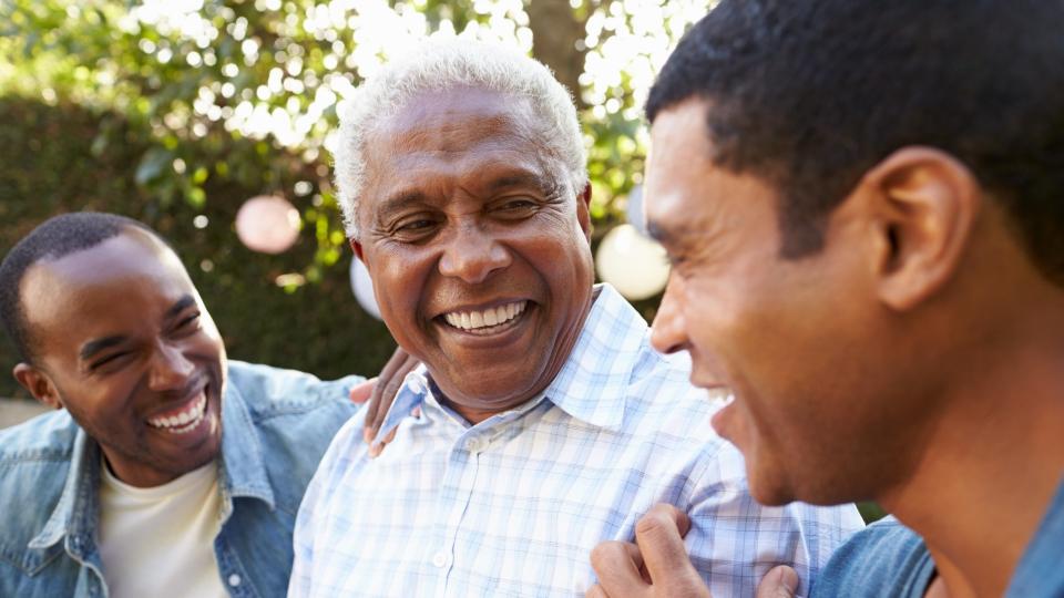 Senior man talking with his adult sons in garden, close up.