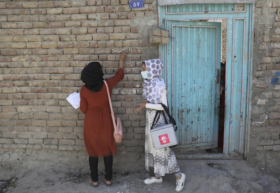 A health worker makes a mark on the door of a house after vaccinating the children of the family during a polio campaign in the old part of Kabul, Afghanistan, Tuesday, June 15, 2021. Gunmen on Tuesday targeted members of polio teams in eastern Afghanistan, killing a number of staffers, officials said. (AP Photo/Rahmat Gul)