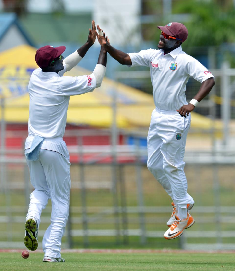 West Indies cricketers Darren Bravo (R) and Darren Sammy celebrate Bravo's catch of Australian batsman David Warner during the fourth day of the second-of-three Test matches between Australia and West Indies April 18, 2012 at Queen's Park Oval in Port of Spain, Trinidad.