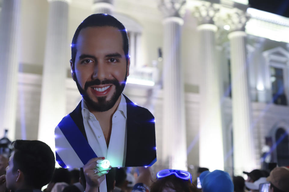 Supporters hold a cut of Salvador President Nayib Bukele, who is seeking re-election, as they gather to celebrate results of a general election at the Gerardo Barrios square in downtown San Salvador, El Salvador, Sunday, Feb. 4, 2024. (AP Photo/Salvador Melendez)
