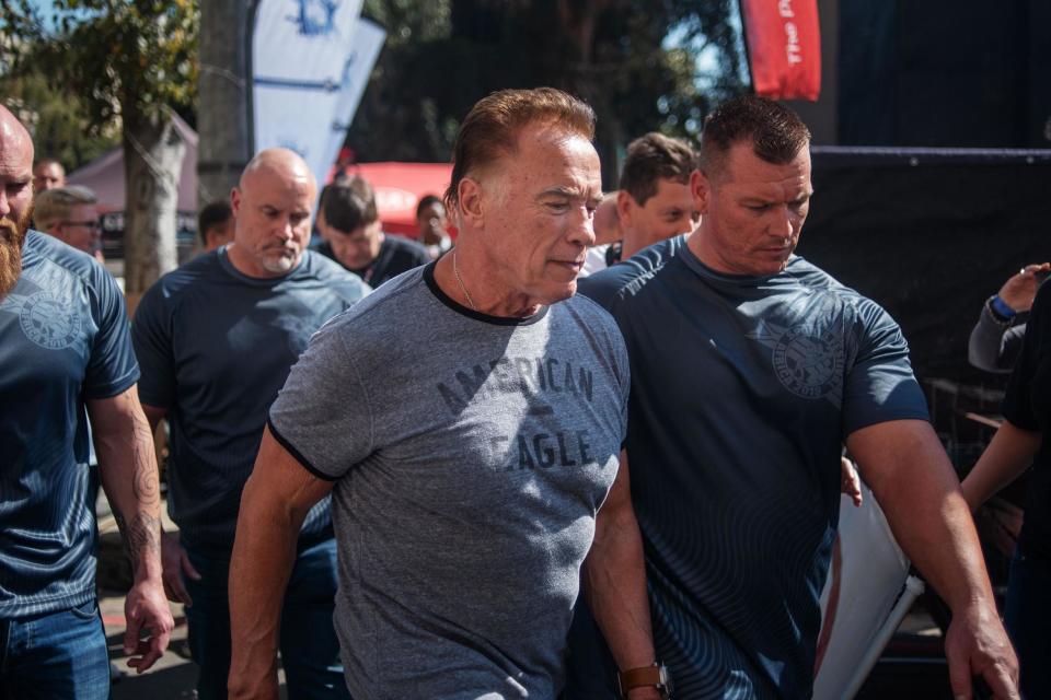 Shocking moment Arnold Schwarzenegger is drop-kicked from behind while posing for selfies at public event