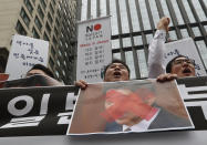 South Korean small and medium-sized business owners with a defaced image of Japanese Prime Minister Shinzo Abe shout slogans during a rally calling for boycott of Japanese products in front of the Japanese embassy in Seoul, South Korea, Monday, July 15, 2019. South Korea and Japan last Friday, July 12, failed to immediately resolve their dispute over Japanese export restrictions that could hurt South Korean technology companies, as Seoul called for an investigation by the United Nations or another international body. The signs read: "We don't sell Japanese products." (AP Photo/Ahn Young-joon)