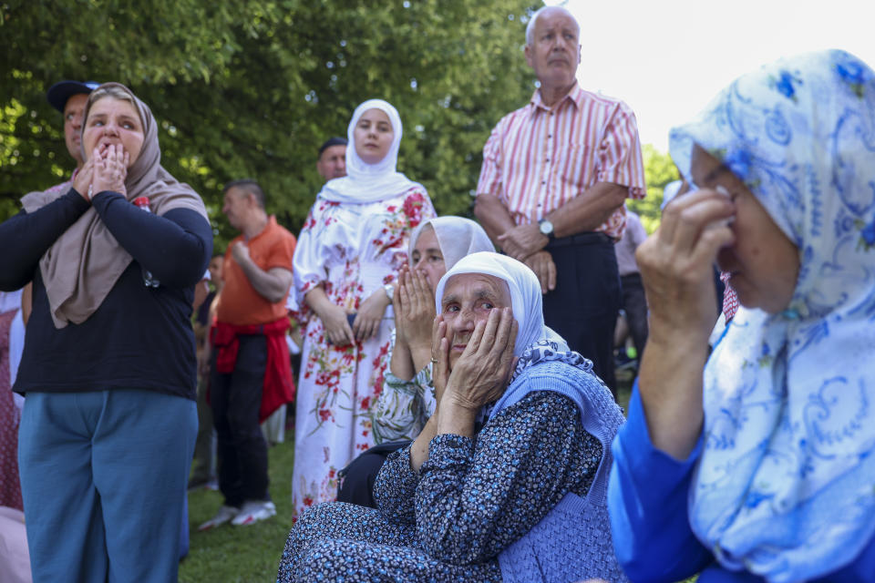 Muslim women pray in Visoko, Bosnia, Sunday, July 9, 2023 next to a truck carrying 30 coffins with remains of the recently identified victims of the 1995 Srebrenica genocide. So far, the remains of more than 6,600 people have been found and buried at a vast and ever-expanding memorial cemetery in Potocari, outside Srebrenica. (AP Photo/Armin Durgut)