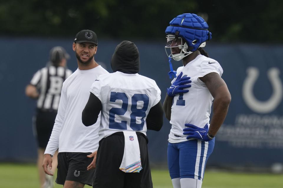 Indianapolis Colts' Michael Pittman Jr., left, talks with Jonathan Taylor (28) and Mo Alie-Cox during NFL football practice at the team's headquarters Wednesday, June 5, 2024, in Indianapolis. (AP Photo/Darron Cummings)