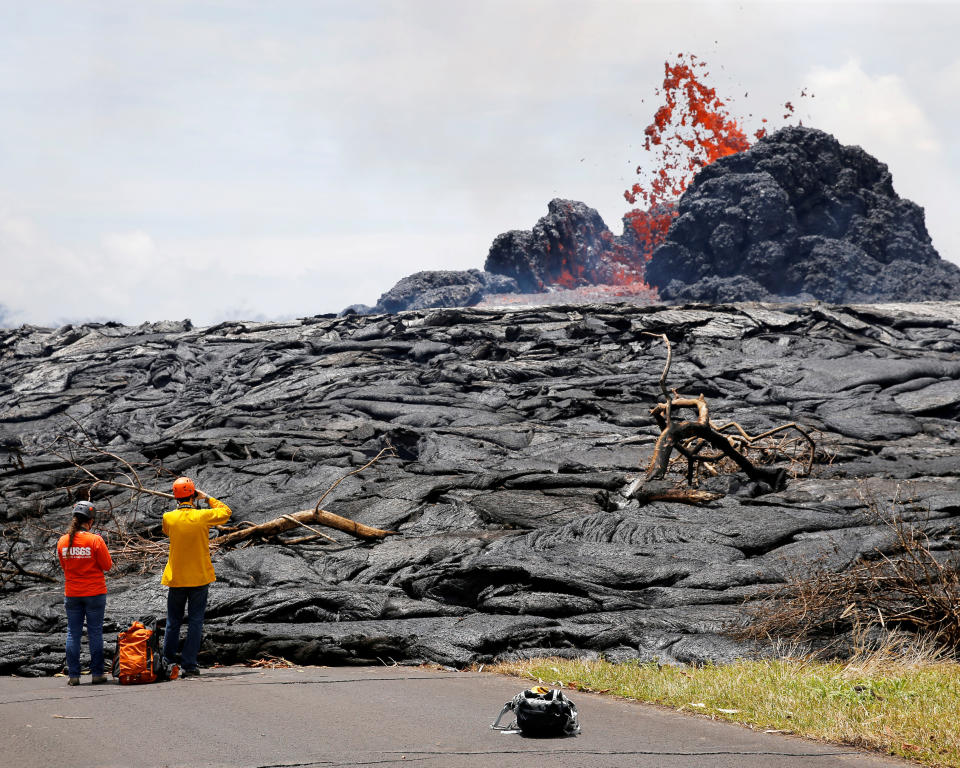 Officials from the U.S. Geological Survey Hawaiian Volcano Observatory&nbsp;watch lava erupting from a fissure in the Leilani Estates near Pahoa, Hawaii, on May 24. (Photo: Marco Garcia/Reuters)