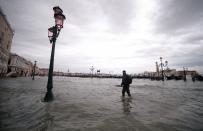 A man walks across the flooded Riva degli Schiavoni embankment by moored gondolas (Rear R) on November 15, 2019 in Venice, two days after the city suffered its highest tide in 50 years. - Flood-hit Venice was bracing for another exceptional high tide on November 15, as Italy declared a state of emergency for the UNESCO city where perilous deluges have caused millions of euros worth of damage. (Photo by FILIPPO MONTEFORTE/AFP via Getty Images)