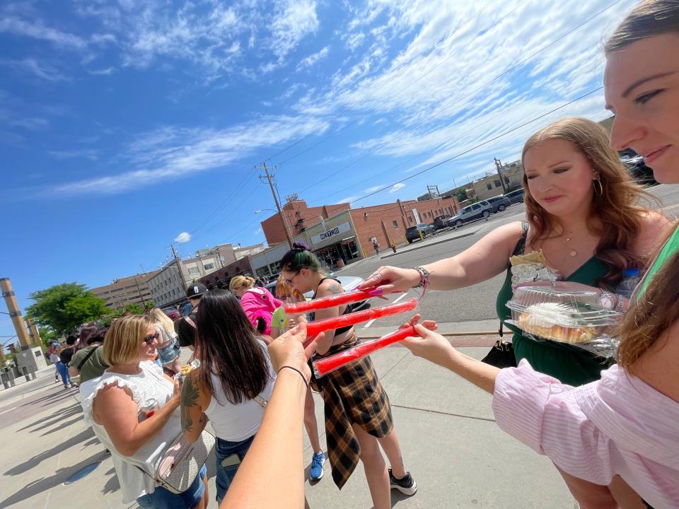 A group of girls holding red popsicles while waiting in line for the Jeffree Star store