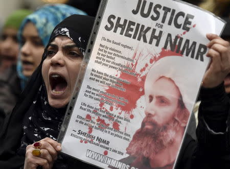 A protester holds a placard during a demonstration against the execution of Shi'ite cleric Sheikh Nimr al-Nimr in Saudi Arabia, outside the Saudi Arabian Embassy in London, Britain, January 3, 2016. REUTERS/Toby Melville