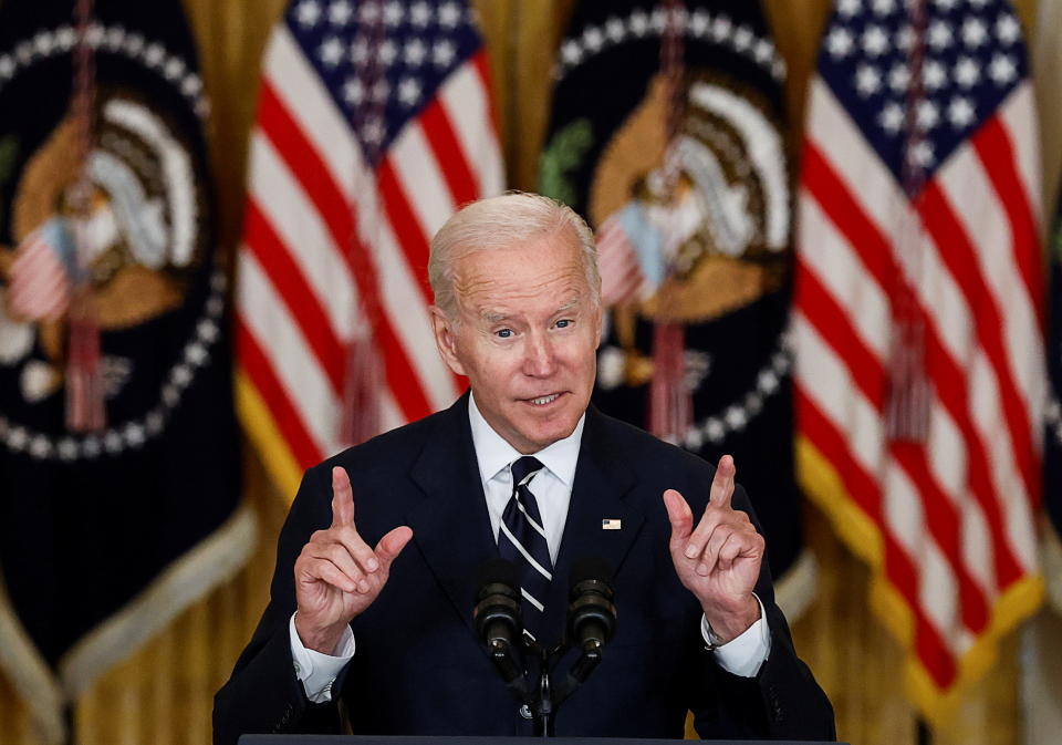 President Biden speaks at a podium in the East Room of the White House.