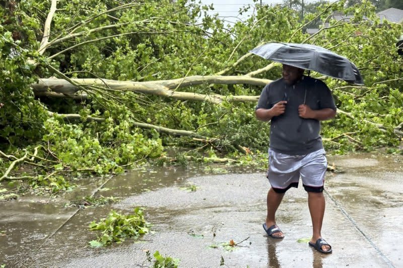 A man looks on Monday at a fallen tree knocked over by wind and rain from Hurricane Beryl in Houston, Tex. The storm, which already caused widespread damage last week in the Caribbean, was downgraded to a tropical storm as it passed over the Gulf of Mexico before regaining strength into a hurricane. Photo Provided by Carlos Ramirez/EPA-EFE