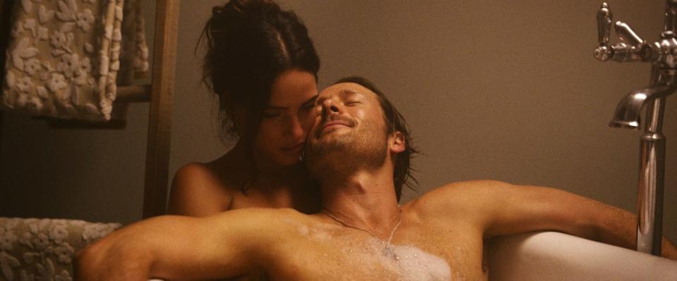 Adria Arjona and Glen Powell in a bath in ‘Hit Man’