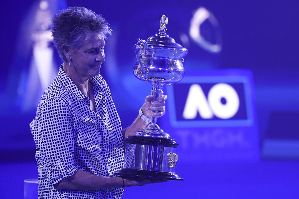 Former Australian Open women's champion Chris O'Neil carries the Daphne Akhurst Memorial Cup onto he court ahead of the final between Ash Barty of Australia and Danielle Collins of the U.S., at the Australian Open tennis championships in Saturday, Jan. 29, 2022, in Melbourne, Australia. (AP Photo/Hamish Blair)