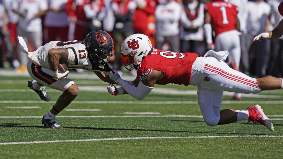 Utah defensive end Gabe Reid tackles Oregon State wide receiver Jesiah Irish (13) during the first half of an NCAA college football game, Saturday, Oct. 1, 2022, in Salt Lake City. (AP Photo/Rick Bowmer)