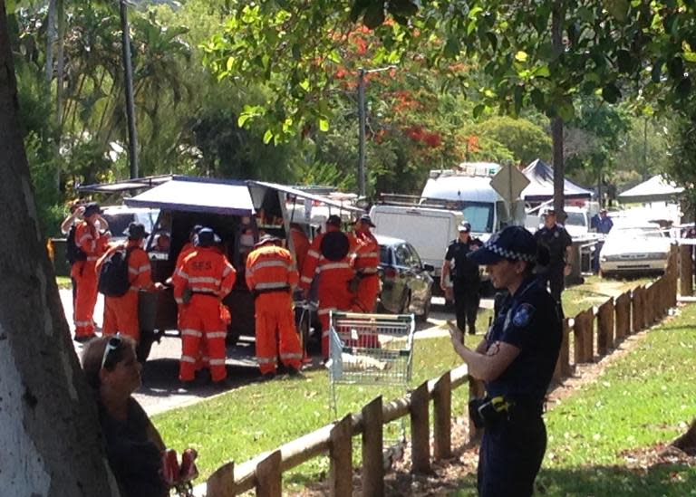 Police gather outside a house where eight children ranging from babies to teenagers were found dead in the northern Australian city of Cairns on December 19, 2014