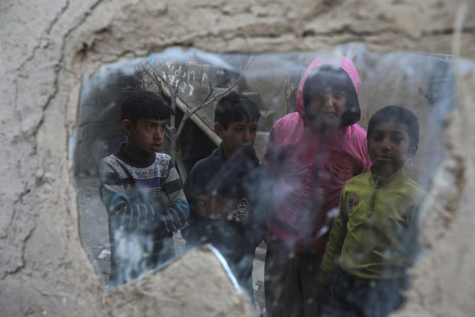 Internally displaced boys are reflected in a mirror inside their temporary home in the city of Kabul, Afghanistan, Wednesday, Dec. 30, 2020. Save the Children has warned that more than 300,000 Afghan children face freezing winter conditions that could lead to illness, in the worst cases death, without proper winter clothing and heating. (AP Photo/Rahmat Gul)