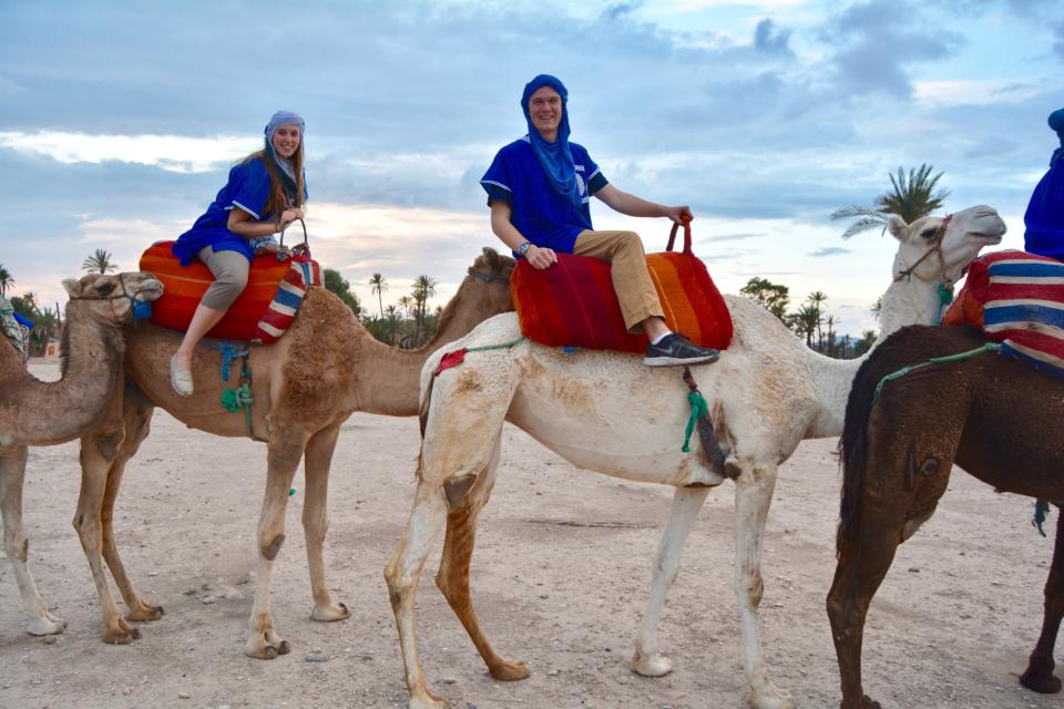 woman and man riding camels