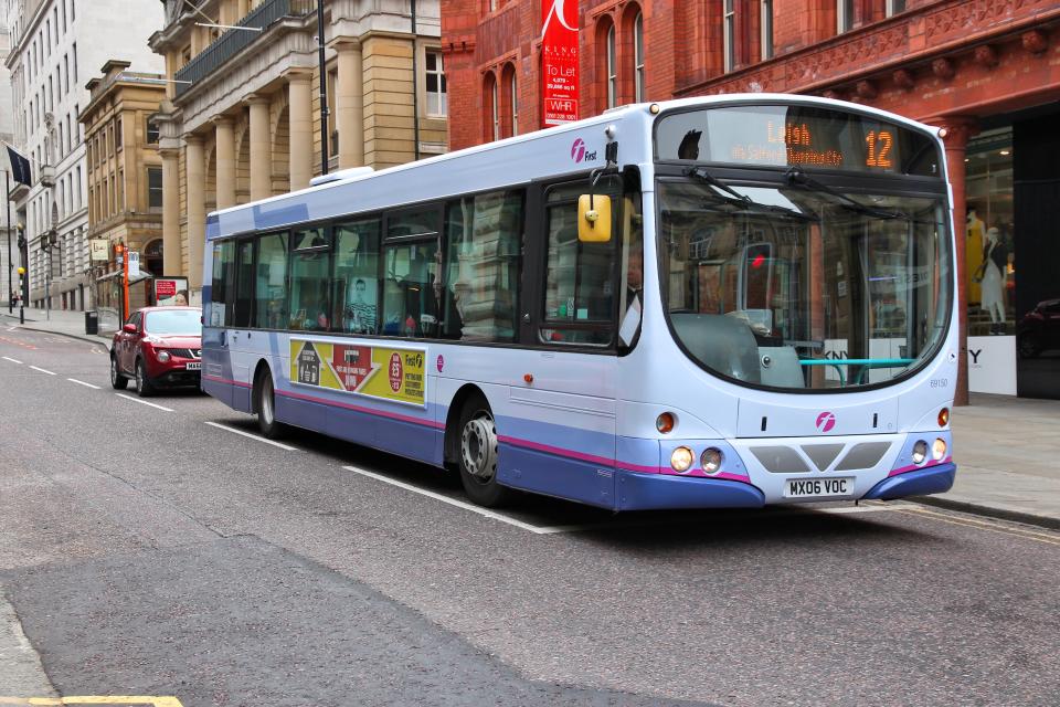 Manchester, United Kingdom - April 22, 2013: People ride FirstGroup city bus in Manchester, UK. FirstGroup employs 124,000 people.