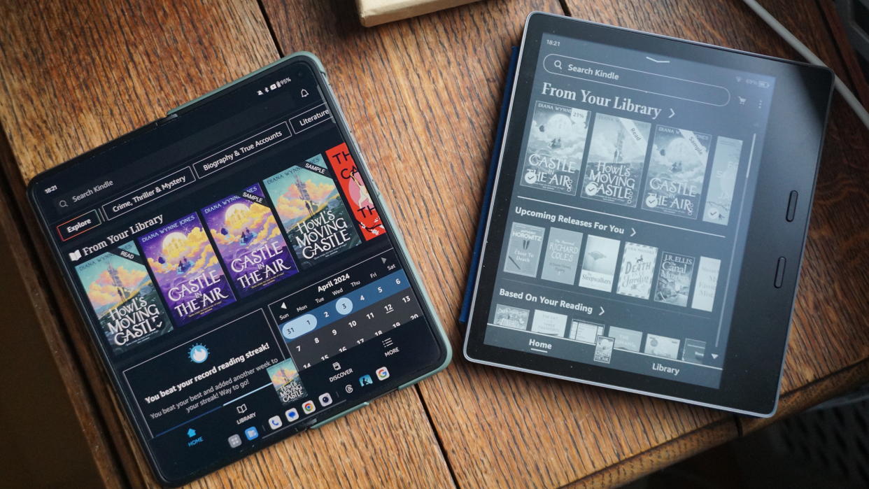  OnePlus Open and Amazon Kindle Oasis on table. 