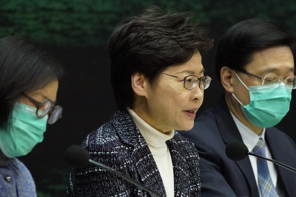 Hong Kong Chief Executive Carrie Lam, center, speaks during a press conference in Hong Kong Wednesday, Feb. 5, 2020. In Hong Kong, hospitals workers are striking to demand the border with mainland China be shut completely to ward off the virus, but four new cases without known travel to the mainland indicate the illness is spreading locally in the territory. (AP Photo/Vincent Yu)