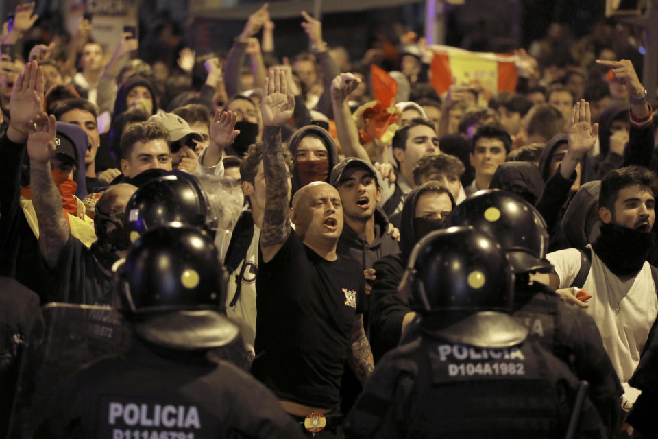 Right wing pro-Spanish unity supporters challenge police officers during a demonstration in Barcelona, Spain, Thursday, Oct. 17, 2019. Catalonia's separatist leader vowed Thursday to hold a new vote to secede from Spain in less than two years as the embattled northeastern region grapples with a wave of violence that has tarnished a movement proud of its peaceful activism. (AP Photo/Emilio Morenatti)