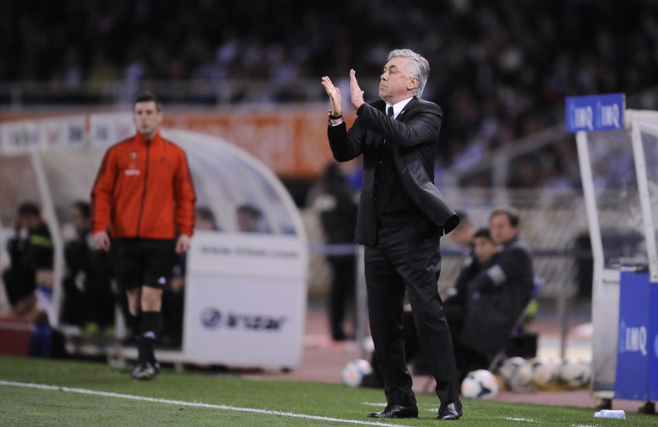 Real Madrid's head coach Carlo Ancelotti of Italy, applauds his team after scoring the fourth goal against Real Sociedad, during their Spanish League soccer match, at Anoeta stadium, in San Sebastian, Spain, Saturday, April 5, 2014. (AP Photo/Alvaro Barrientos)