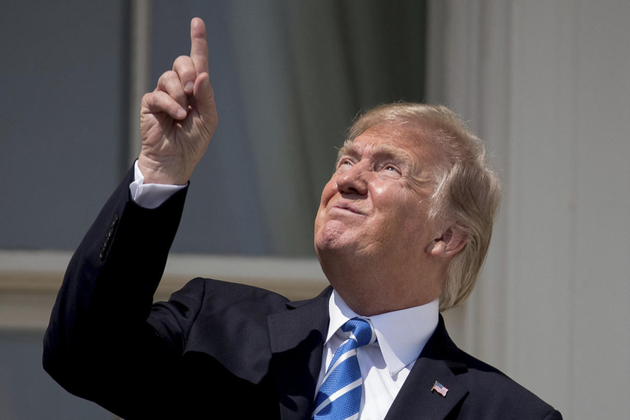 Image: President Donald Trump points to the sun as he arrives to view the solar eclipse, Aug. 21, 2017, at the White House in Washington. (Andrew Harnik / AP)