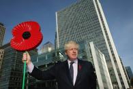 LONDON, ENGLAND - OCTOBER 30: Mayor of London Boris Johnson holds a giant Poppy during a photocall after being winched on board HMS Severn on October 30, 2012 in London, England. Mr Johnson was taking part in the event to raise awareness of the Royal British Legion's Poppy Day appeal. This year will be the first time that customers can pay for a poppy using contactless technology on their credit cards. The money raised from the sale of the poppy badges will go towards the Royal British Legion's fund to support the armed forces. (Photo by Dan Kitwood/Getty Images)