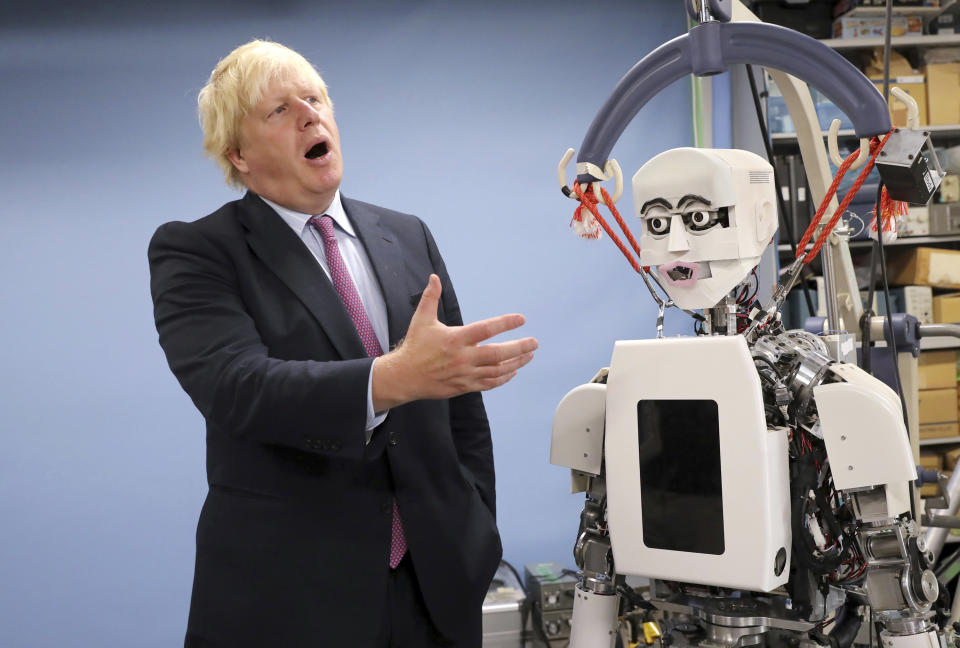 FILE - Britain's Foreign Secretary Boris Johnson gestures as he looks at a humanoid robot at Research Institute for Science and Engineering at Waseda University's campus in Tokyo Thursday, July 20, 2017. British media say Prime Minister Boris Johnson has agreed to resign on Thursday, July 7 2022, ending an unprecedented political crisis over his future. (AP Photo/Eugene Hoshiko, file)