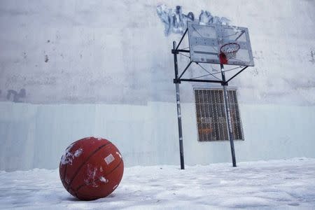 A basketball sits on a frozen basketball court in Lower Manhattan, New York February 16, 2015. REUTERS/Andrew Kelly