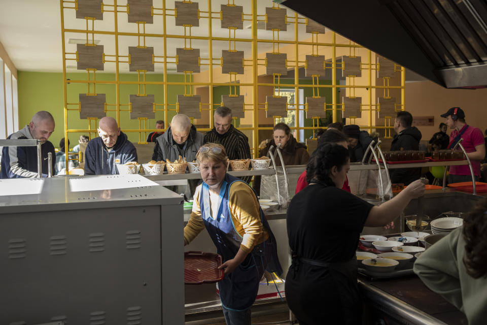 Internally displaced have lunch at school cantine in Lviv, western Ukraine, Monday, March 14, 2022. Overnight, air raid alerts sounded in cities and towns around the country, from near the Russian border in the east to the Carpathian Mountains in the west, and fighting continued on the outskirts of Kyiv. Ukrainian officials said Russian forces shelled several suburbs of the capital. (AP Photo/Bernat Armangue)