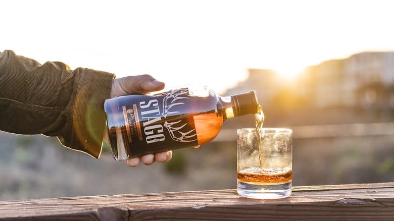 man pouring Stagg bourbon into glass