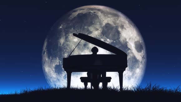 Piano and pianist silhouetted against the moon