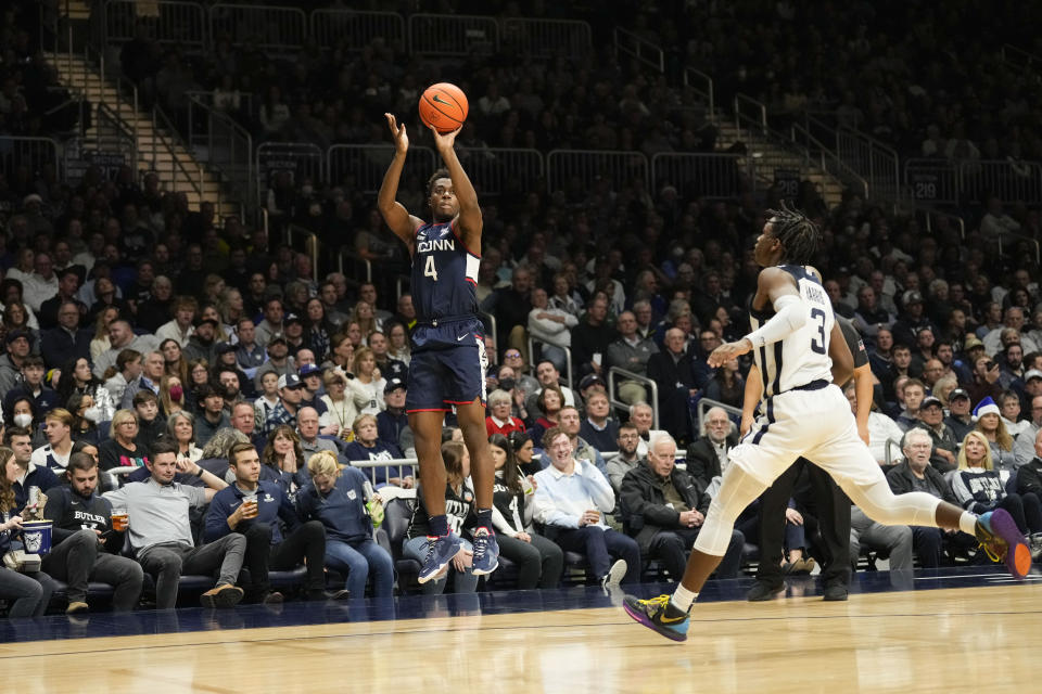 Connecticut guard Nahiem Alleyne (4) shoots in front of Butler guard Chuck Harris (3) in the second half of an NCAA college basketball game in Indianapolis, Saturday, Dec. 17, 2022. (AP Photo/AJ Mast)