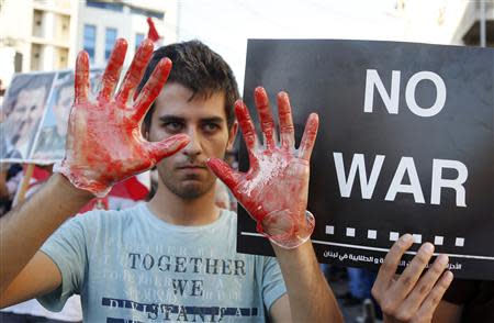 An activist shows his hands while wearing gloves covered in fake blood during a sit-in near the U.S. embassy in Awkar, north of Beirut, against potential U.S. strikes on Syria September 6, 2013. REUTERS/Mohamed Azakir